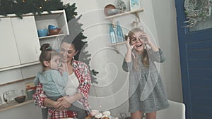 Happy family in the kitchen. Mother and children preparing the dough, bake cookies