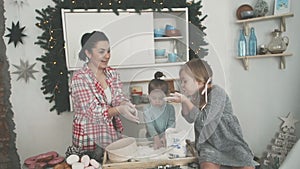 Happy family in the kitchen. Mother and children preparing the dough, bake cookies