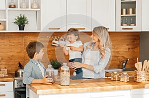 Happy family in the kitchen. mother and children preparing the dough, bake cookies photo