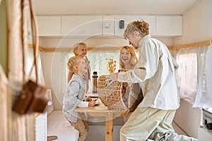 Happy family on kitchen in trailer, summer camping