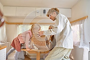 Happy family on kitchen in trailer, summer camping