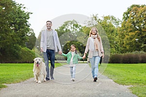 Happy family with labrador retriever dog in park