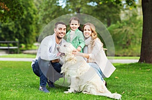 Happy family with labrador retriever dog in park