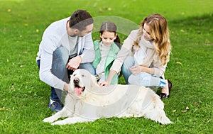 Happy family with labrador retriever dog in park