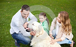 Happy family with labrador retriever dog in park