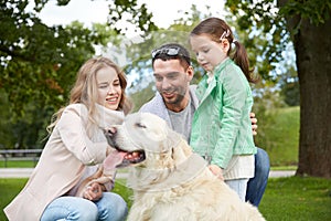 Happy family with labrador retriever dog in park