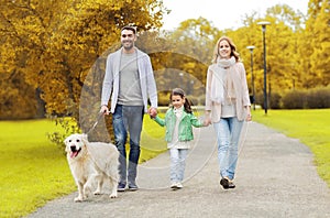 Happy family with labrador retriever dog in park