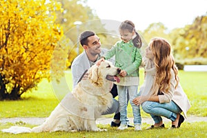 Happy family with labrador retriever dog in park