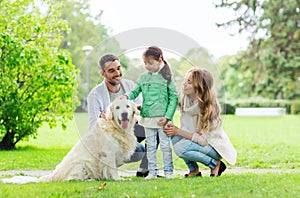 Happy family with labrador retriever dog in park