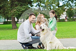 Happy family with labrador retriever dog in park