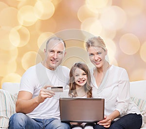 Happy family with laptop computer and credit card