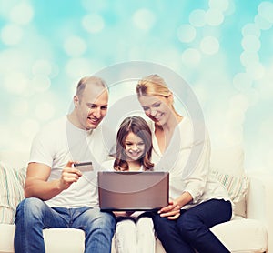 Happy family with laptop computer and credit card