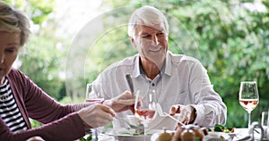 Happy family, laughing and dining together for lunch, meal or bonding by table in garden at home. Grandparents, parent