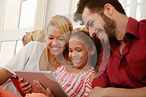 Happy Family Laughing Looking At Video On Tablet Computer