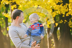 Happy family laughing and playing in autumn wood