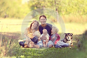 Happy Family Laughing Together with Dog Outside photo