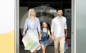 Happy Family Leaving Shopping Mall Carrying Shopper Bags