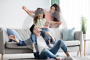 Happy Family Leisure. Cheerful arabic mom, dad and daughter having fun together