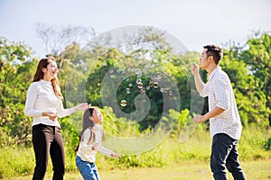 Happy family life concept. Asian parents Father, Mother and the little girl enjoying and fun during playing soap bubbles. family