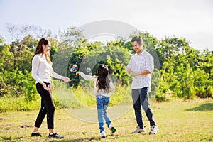 Happy family life concept. Asian parents Father, Mother and the little girl enjoying and fun during playing soap bubbles. family