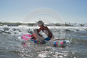 Happy family lifestyle.  Smiling young mother and son jumping and splashing with fun in breaking waves