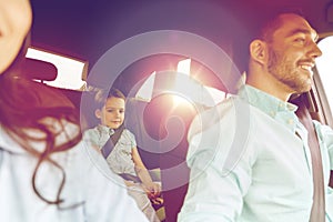 Happy family with little child driving in car