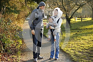 Happy family with little child outing in autumn park