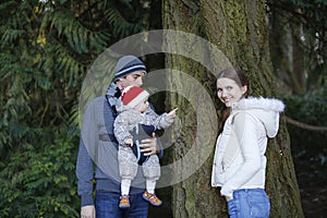 Happy family with little child outing in autumn park