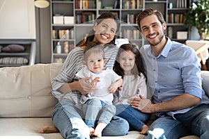 Happy family with little children relax on couch