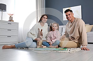 Happy family with little daughter spending time together at home. Floor heating concept