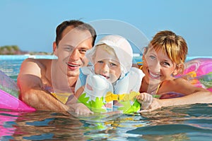 Happy family with little girl bathing in pool