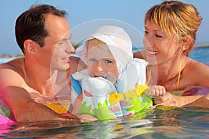 Happy family with little girl bathing in pool