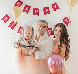 Happy family with little girl celebrating birthday party