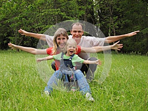 Happy family with little girl on meadow