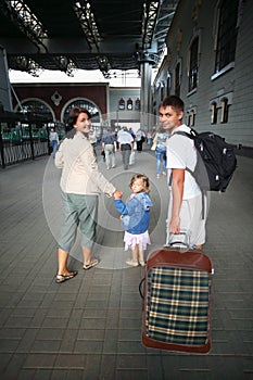 Happy family with little girl at railway station