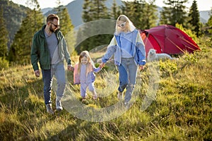 Happy family with little girl travel in the mountains