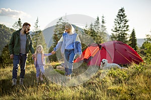Happy family with little girl travel in the mountains