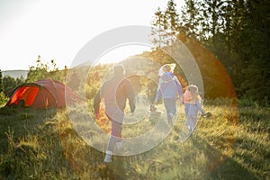 Happy family with little girl travel in the mountains