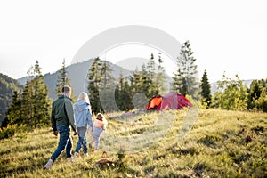 Happy family with little girl travel in the mountains