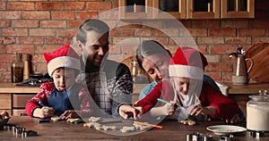 Happy family with little kids decorate homemade baked Christmas cookies