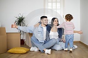 Happy family with little son having fun at new home after moving