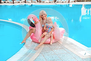 Happy family look. Mother with daughter. Beautiful blond woman with having fun with little pretty gil wears in swim wear posing on