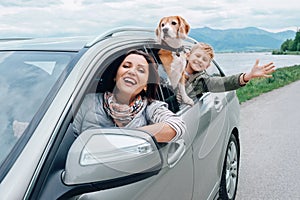 Happy family look out from car windows photo