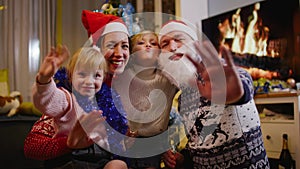 Happy family looking at the camera and greeting at Christmas eve at home