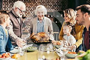 happy family looking at delicious thanksgiving turkey in hands