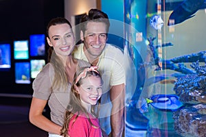 Happy family looking at fish tank