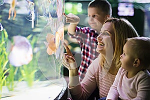 Happy family looking at fish tank at the aquarium