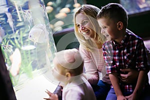 Happy family looking at fish tank at the aquarium