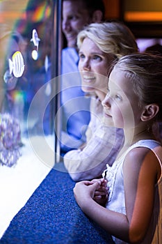 Happy family looking at starfish in a tank