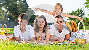 Happy family lying on blanket on picnic